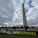Immigrant organization rally in front of the Washington Monument in Washington DC holding a banner for safety, justice, dignity and respect for all immigrants.