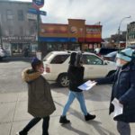 Two women are walking by on a side walk as one of our COVID-19 Outreach Team members is distributing flyers about the COVID-19 tests.