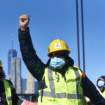 Excluded worker raises his fist in solidarity with marchers on Manhattan bridge.