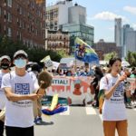 Minkwon Center for Community Action lead hundreds with a drum band to march over the Manhattan Bridge.
