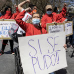 Our member Rubi holds a banner "Si se puede" on teh victory of the Excluded Workers Fund.