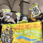 Members of the community hold a Make the Road NY banner.